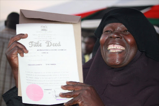 IT'S MINE: Said Sharrif from Mwakirunge shows the title deed she received from President Uhuru Kenyatta at Khadija Grounds, Mombasa on August 13, 2013. Photo/FILE