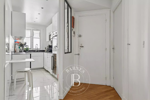 Modern white equipped kitchen and entrance - Buy this luxury apartment / penthouse in Paris 7ème, 3 rooms, 2 bedrooms