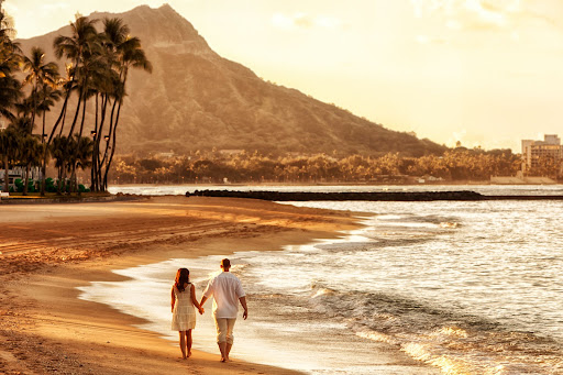 Couple walking on Waikiki Beach at sunrise, Hawaii