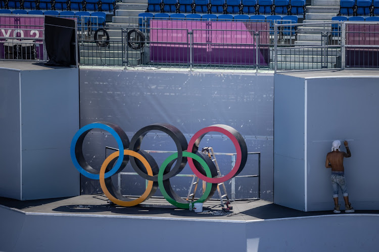 A technician works next to Olympic rings at Ariake Urban Sports Park on July 22 2021 in Tokyo, Japan. Picture: GETTY IMAGES/CARL COURT