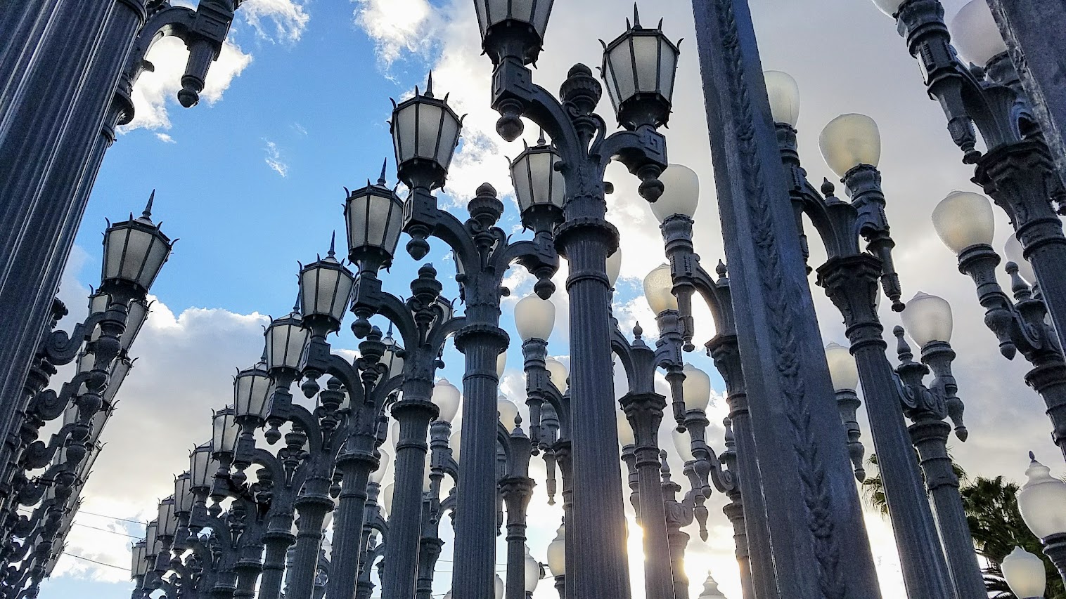 One of the most famous and free (since it is an outdoor sculpture) art you can see in the park at LACMA is the iconic Urban Lights. Created by Chris Burden, it is made of 202 restored street lamps in various styles based on where they were from (most are from southern California and some from Portland Oregon too!). The lamps are painted grey and assembled in a grid, and are solar powered and become lit in the evening.