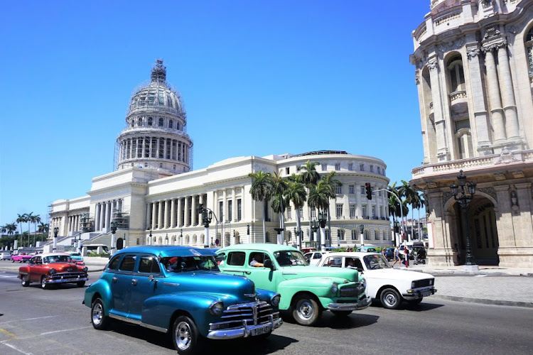 Classic cars in front of a government building in Havana, Cuba. 