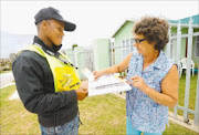 IDENTITY VERIFICATION: Census fieldworker Simphiwe Faku introduces himself to Jennifer Steyn at her home in Sherwood, Port Elizabeth.  
      Photo: BRIAN WITBOOI.