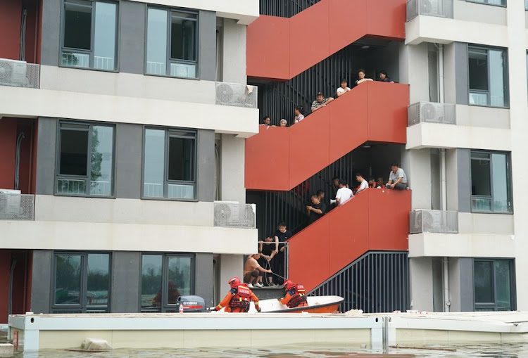 Firefighters drive a rescue boat to evacuate people in Fangshan District of Beijing, capital of China, Aug. 2, 2023.