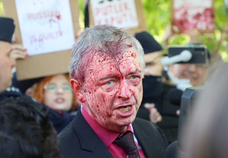 Russia's ambassador to Poland Sergey Andreev is covered in red substance thrown by protesters as he came to celebrate Victory day at the Soviet Military Cemetery to mark the 77th anniversary of the victory over Nazi Germany, in Warsaw, Poland May 9, 2022.