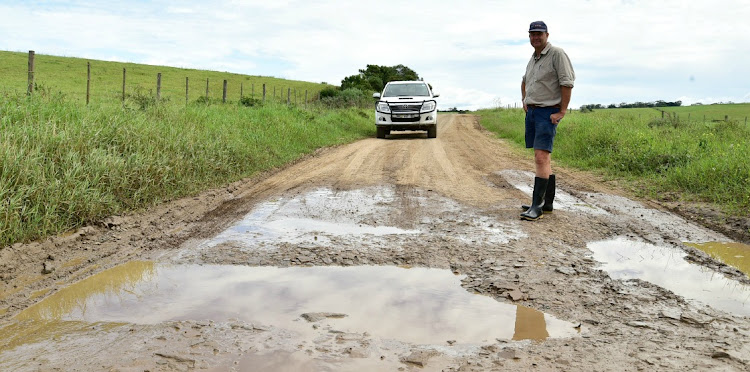MUD BATH: Zuney Valley dairy farmer Cliffie Biggs points out one of the many bad patches along the busy DR1948