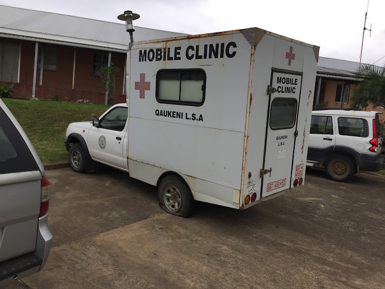 A rusted mobile clinic with a flat tyre parked outside an Eastern Cape hosppital.