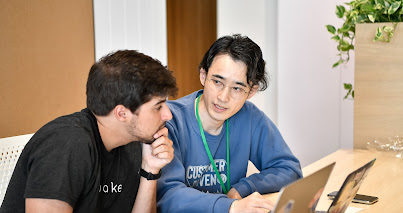 Two men with laptops talking