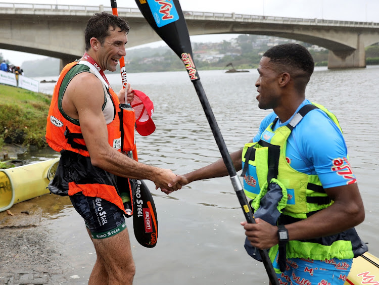 Andy Birkett and Msawenkosi Mtolo congratulate each other after finishing first and second in the Dusi canoe marathon.