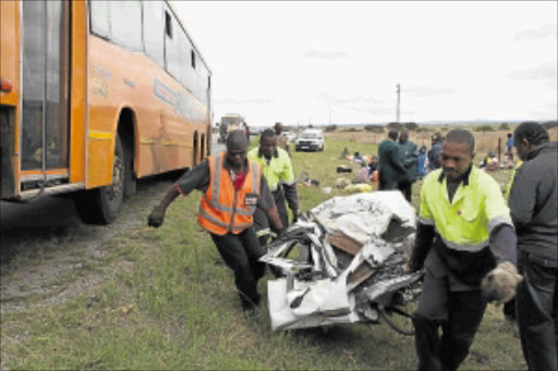 AFTERMATH : Paramedics carry the wreckage of a sedan that collided with a Putco bus. PHOTO: ELIJAR MUSHIANA