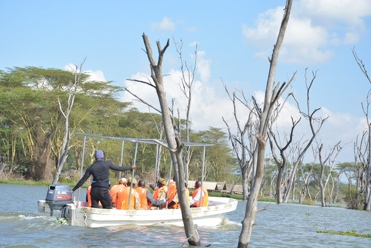 Visitors to Lake Naivasha pass next to one of the submerged structures near Karagita landing beach following a sharp rise in water levels.