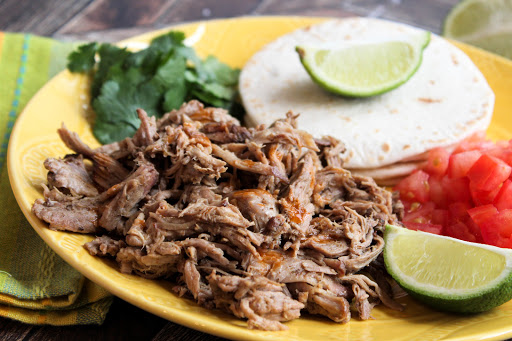 Mexican Pulled Pork Yucatan Style on a plate with tortillas.