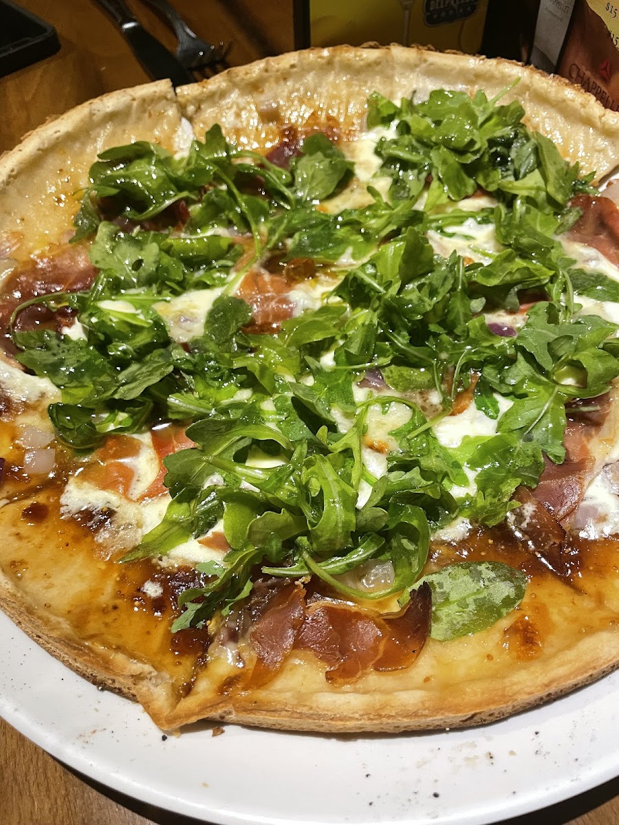 Pizza with arugula and fig jam and proscuitto