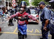 Papy Sukami was hauled away from the Waldorf Arcade in Cape Town as police used stun grenades and water cannons to disperse the crowd. 