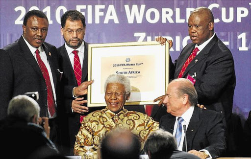 The South African delegation of Irvin Khoza, Danny Jordaan and Nelson Mandela, with Fifa president Sepp Blatter and Molefi Oliphant showing the name of South Africa at the announcement that the country would host the 2010 Soccer World Cup, during an official ceremony in Zurich, Switzerland, on May 15 2004. Picture: EPA