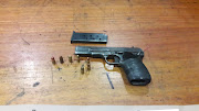 Police arrested a 21-year-old man in possession of a 9mm pistol and ammunition on Tuesday. He was wanted in connection with a murder and three attempted murders.