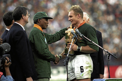 Nelson Mandela takes his reconciliation project to the heart of white SA as he congratulates Bok captain Francois Pienaar on winning the Rugby World Cup in 1995.