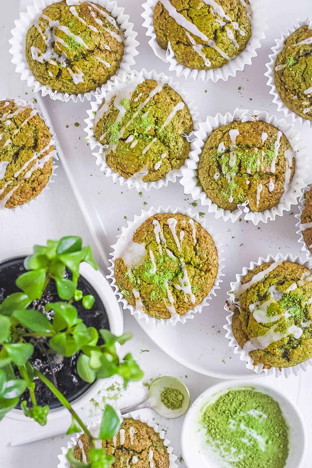 Matcha muffins with a glaze drizzle and matcha powder.