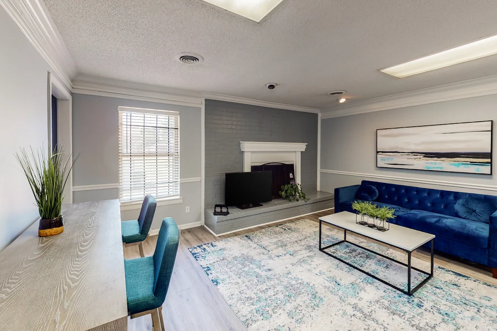 Leasing office lounge area with desk, plush couch, and fireplace