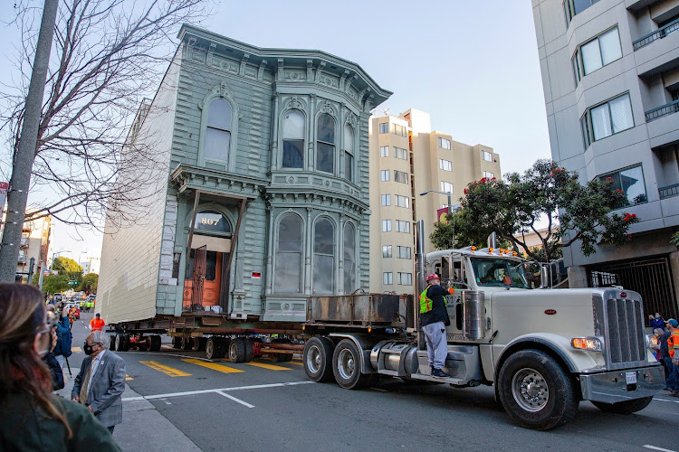 A 139-year-old Victorian house is hoisted towards its new location six blocks away, as the original site is to be used to build a block of flats in San Francisco.
