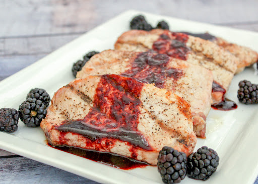 Blackberry balsamic reduction sauce drizzled over grilled pork chops.