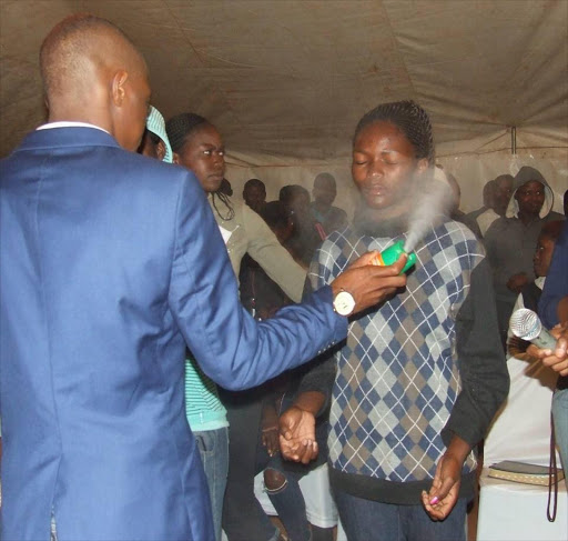 Prophet Lethebo Rabalago sprays Doom on a congregant at Mount Zion General Assembly (MZGA) account.