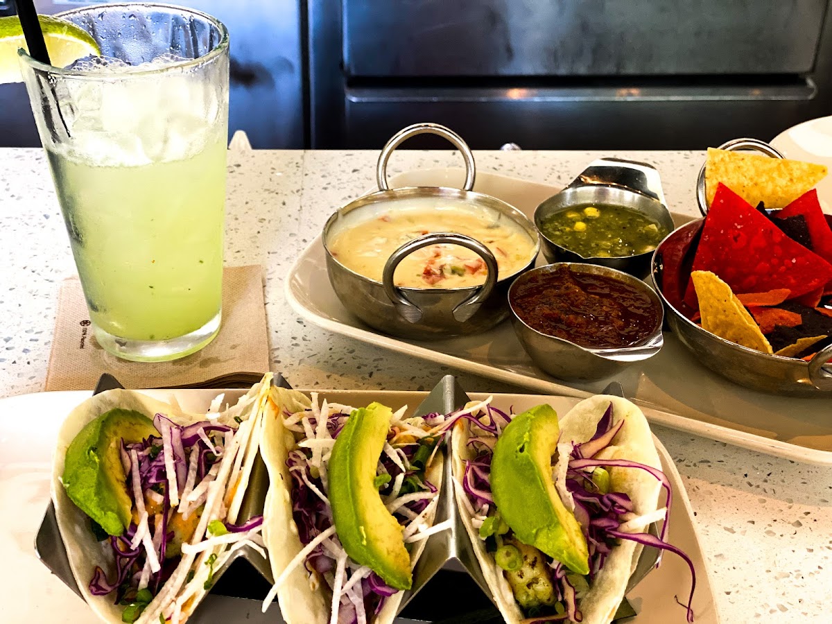 Shrimp tacos with added avocado and chips and queso