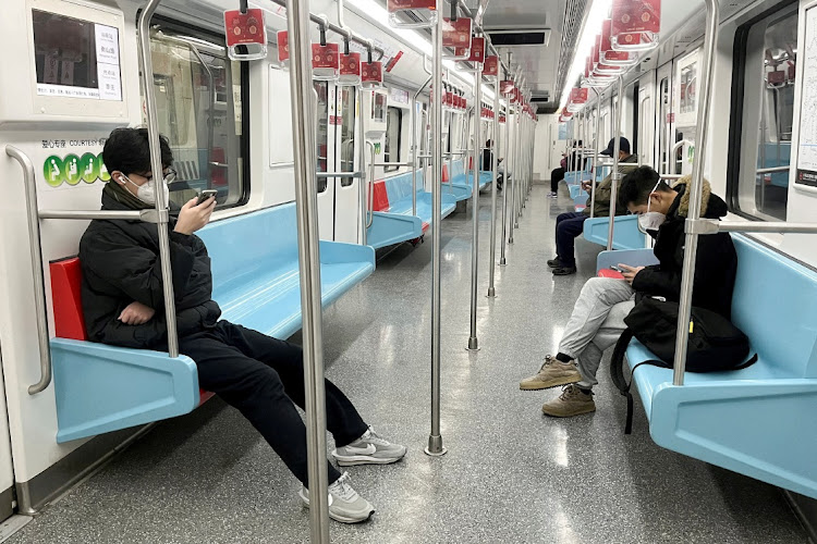 ommuters wear protective masks while they ride a subway train in Shanghai, China, on December 20 2022. Picture: REUTERS/CASEY HALL
