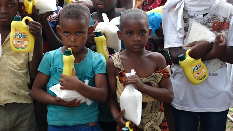 Children from poverty-stricken families hold some of the goodies that had been donated by a wellwisher in Ganda Malindi