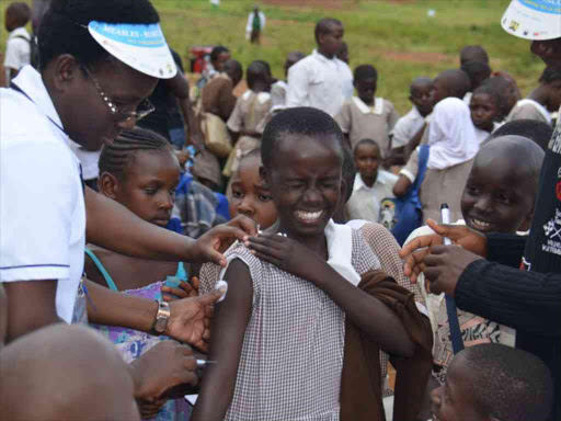 A Migori Muslim Primary school pupil grimance when Health official administering Measles Rubella vaccine. PHOTO/FILE