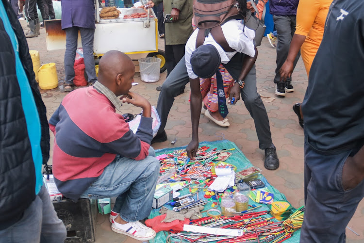 A student selecting pens from a hawker in Nairobi's CBD on Tuesday