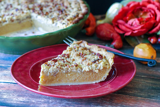 A slice of Acorn Squash Streusel Pie on a red plate.