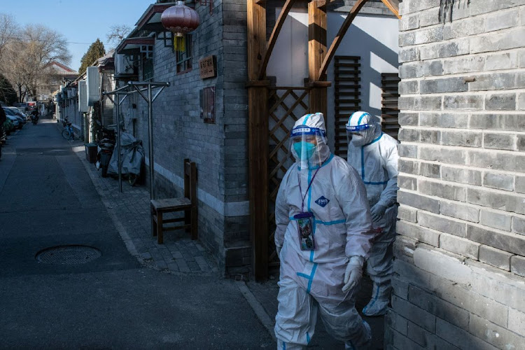 Workers in protective gear in Beijing on December 6 2022. China is reporting fewer Covid-19 cases as a wave that started to accelerate last month appears to be tailing off amid a pullback in the sweeping testing regime that saw a negative result needed to even enter a public park. Picture: Bloomberg