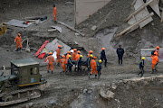 Members of National Disaster Response Force (NDRF) and State Disaster Response Fund (SDRF) carry the body of a victim after recovering it from the debris inside a tunnel during a rescue operation after a flash flood swept a mountain valley destroying dams and bridges, in Tapovan, in the northern state of Uttarakhand, India, on February 14 2021. 