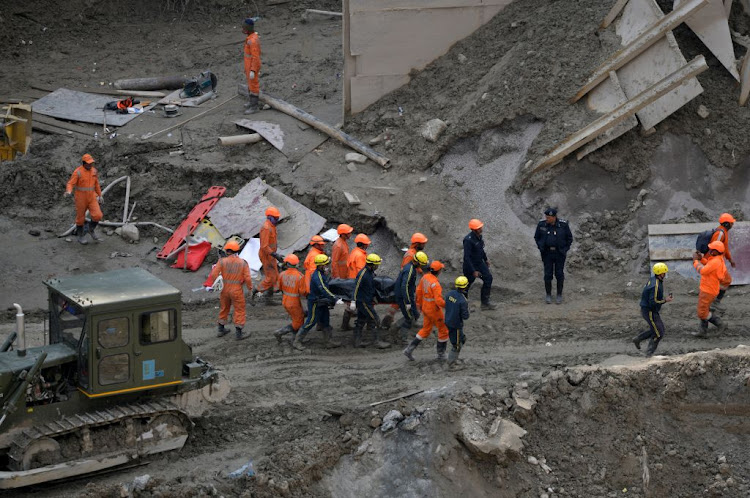 Members of National Disaster Response Force (NDRF) and State Disaster Response Fund (SDRF) carry the body of a victim after recovering it from the debris inside a tunnel during a rescue operation after a flash flood swept a mountain valley destroying dams and bridges, in Tapovan, in the northern state of Uttarakhand, India, on February 14 2021.