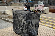 Rasta holds a painting depicting the famous picture taken by the late Sam Nzima in 1976 at the Hector Pieterson memorial site in Soweto.