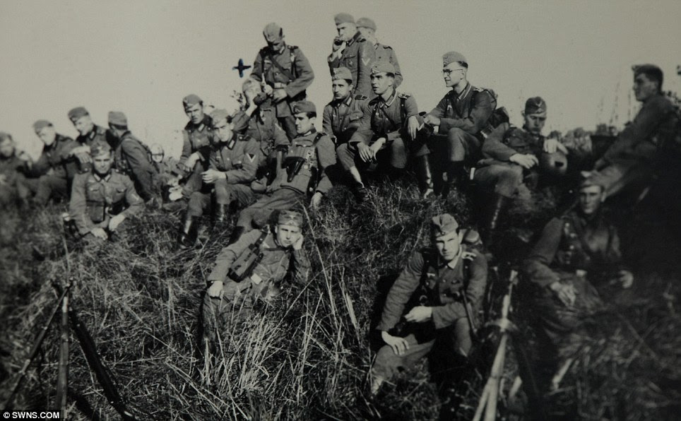 Waiting: A group of soldiers seated on a hill top in Belgium during World War II