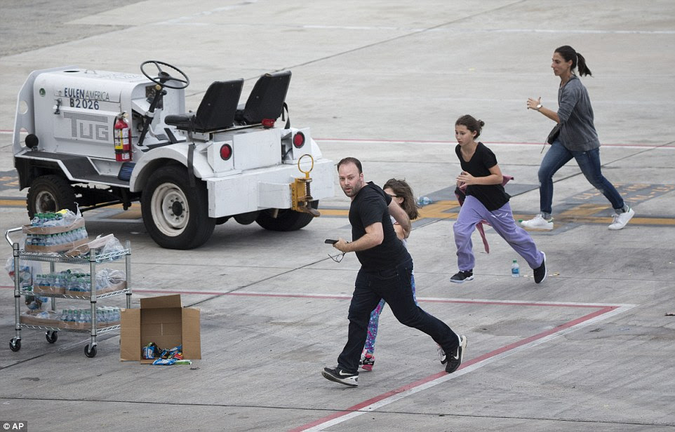 People are seen desperately running across the tarmac after the shooting earlier in the afternoon