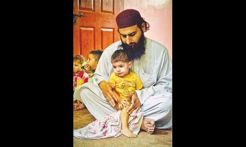 BILAL in the lap of his uncle in their home on Wednesday.—White Star BILAL in the lap of his uncle in their home on Wednesday.—White Star
