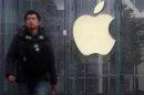 A man walks in front of a company logo outside an Apple store in downtown Shanghai