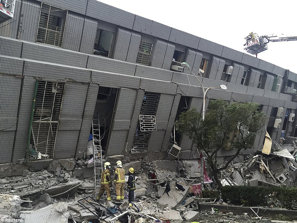 Rescue personnel work at a damaged building - possibly an office block - in the hours after quake