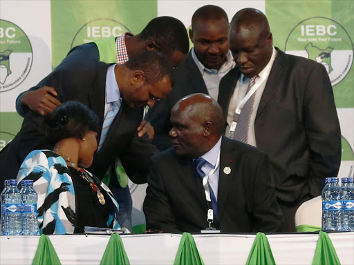 IEBC chairman Wafula Chebukati consults other commissioners and IEBC officials during a media briefing at Bomas of Kenya in Nairobi, July 8, 2017. /JACK OWUOR