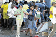 LOOTERS' PARADISE: Police stood by as protesters in Zamdela township in Sasolburg, Free State, burned a delivery truck and looted a liquor store outside the local police station yesterday. Residents then engaged in running battles with the police before reinforcements were called in to quell the protests Pictures: