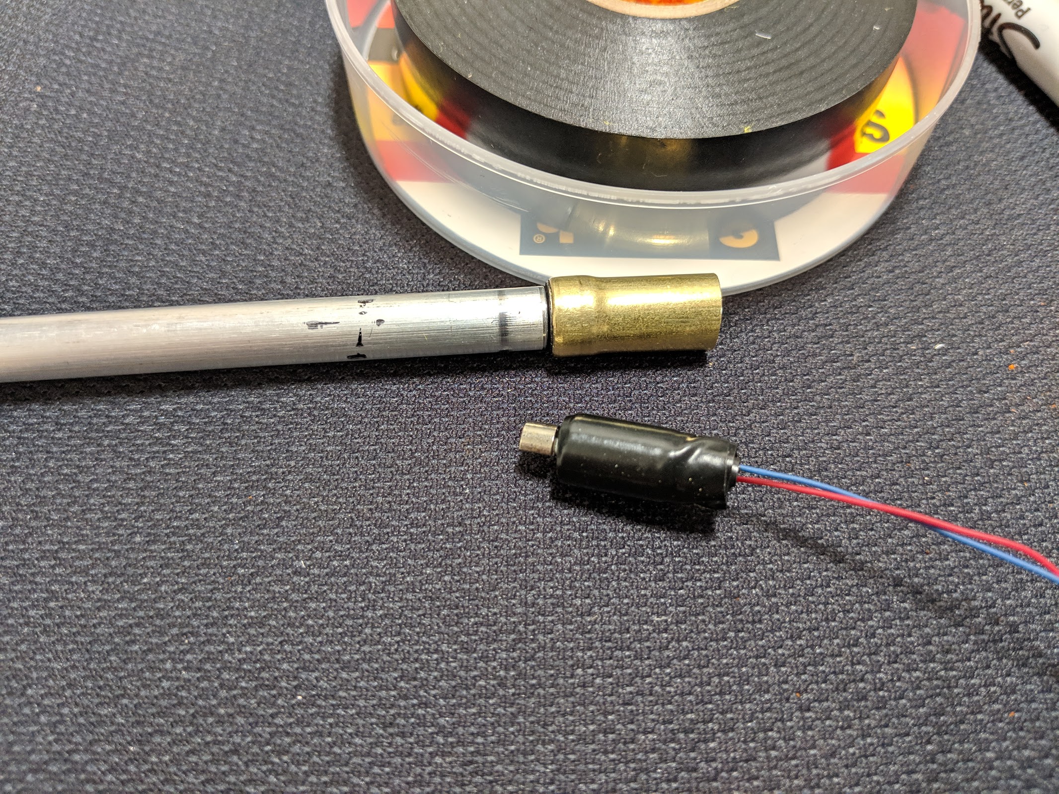 Screw it into the back of the aluminum tube, then wrap the vibration motor in some electrical tape for a press-fit.