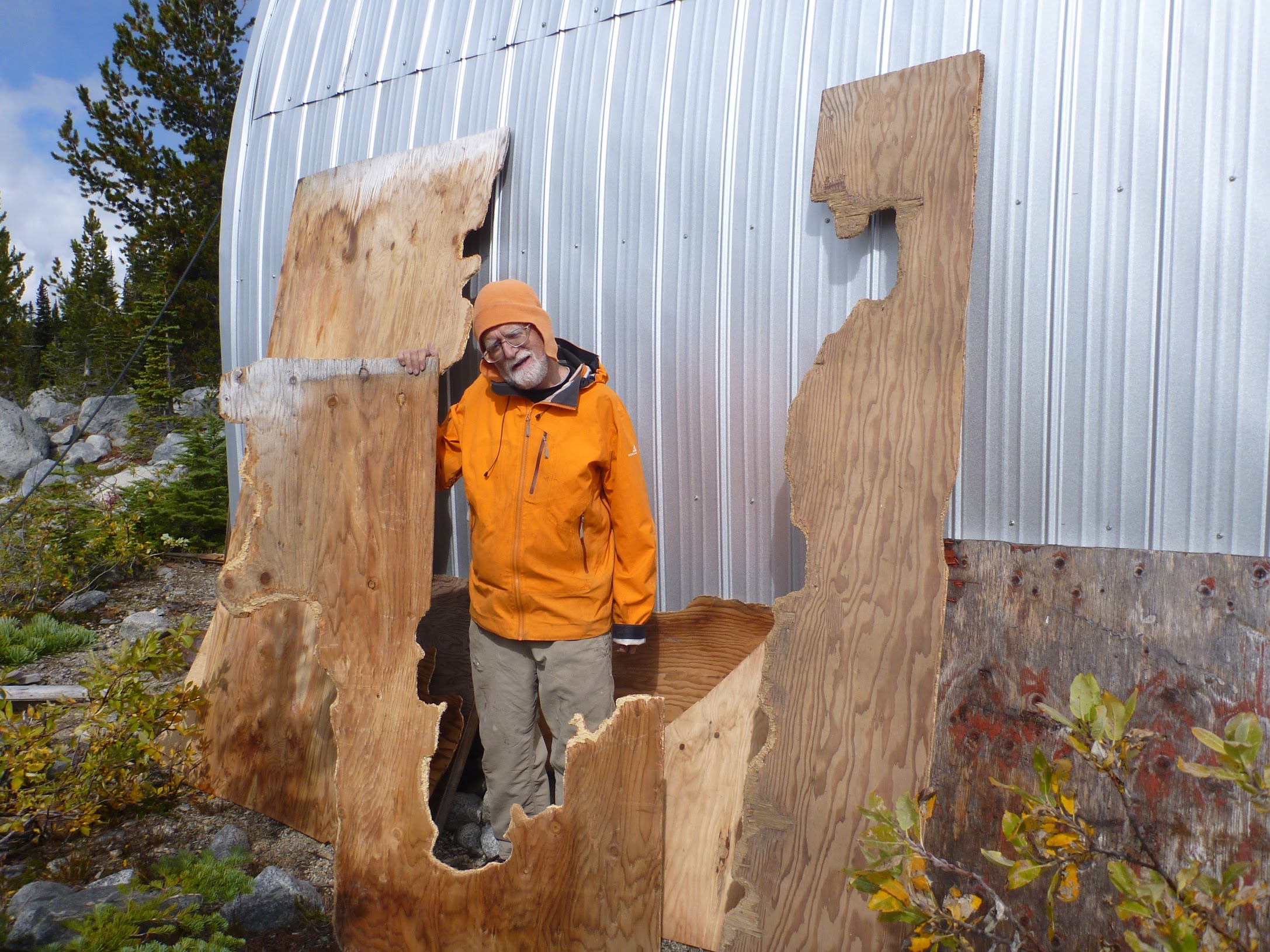 Man standing with marmot-chewed plywood