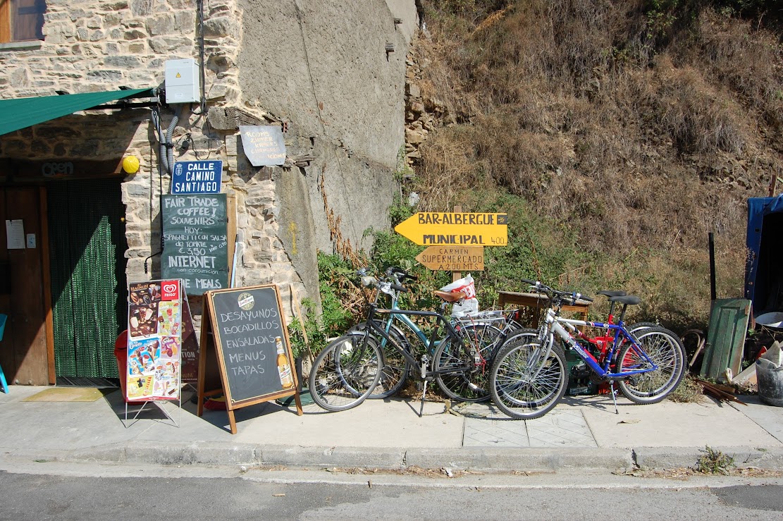 Camino Albergue sign with bikes piled up beside it