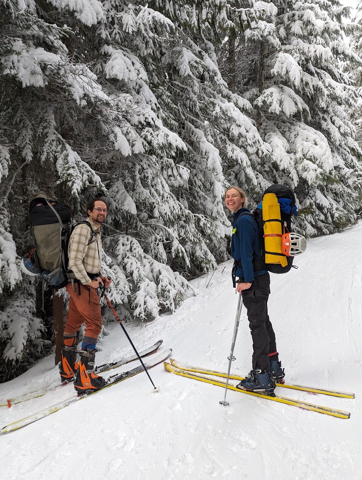 People on skis, with big packs, smiling