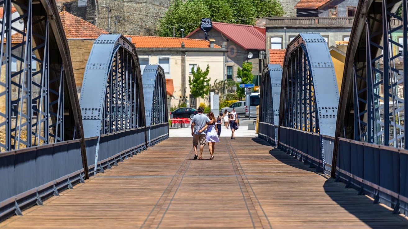 Couple walking along wooden foot bridge at Peso da Regua