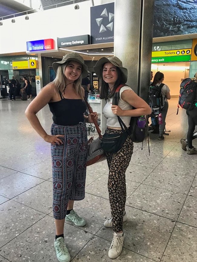 Two happy girls standing in the departure lounge at an airport about to fly to Africa to volunteer at Lilongwe Wildlife Centre in Malawi