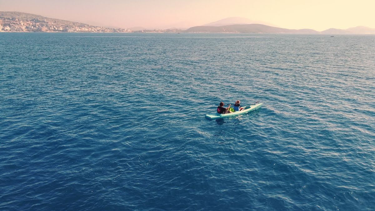 A drone picture of a two people kayaking in the bay in saranda, vlora, county, albania
